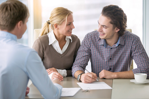 Young smiling couple signing a loan