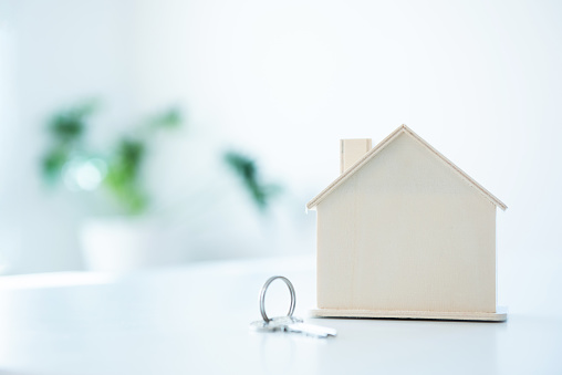 House shape toy with keychain on white table and blank background.